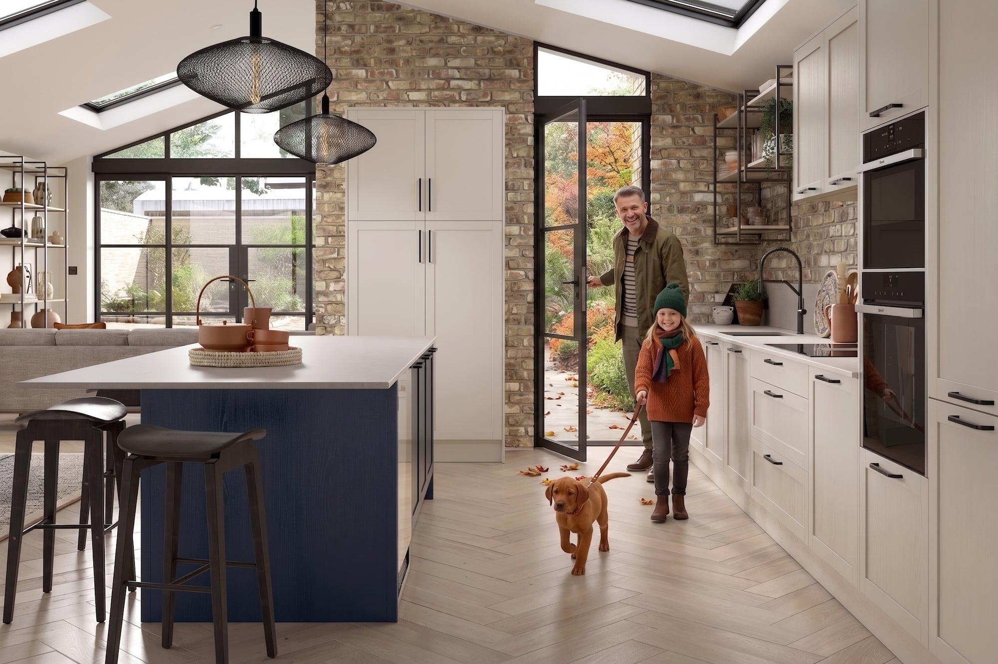 Modern kitchen with a blue island, white cabinets, and a man with a child and dog.